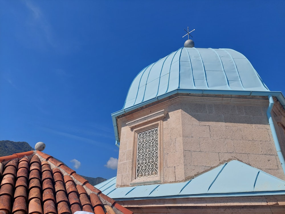 a building with a blue roof and a cross on top