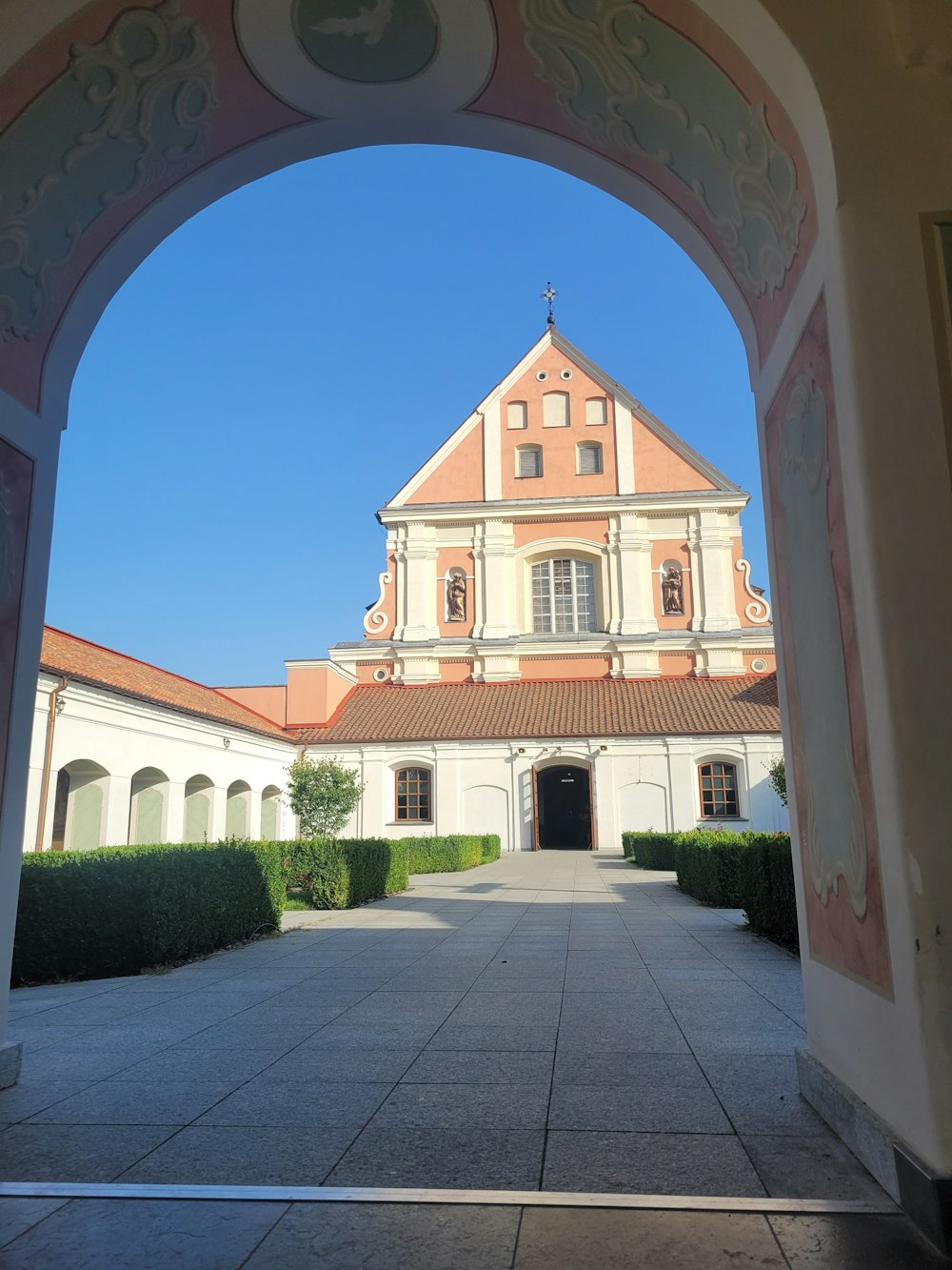 an archway leading to a building with a clock on it