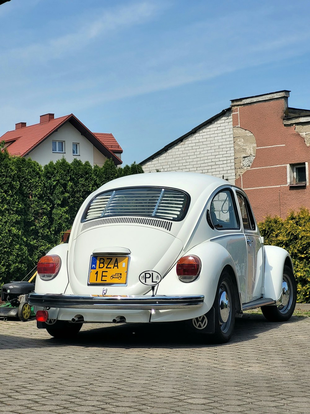a white vw bug parked in front of a house