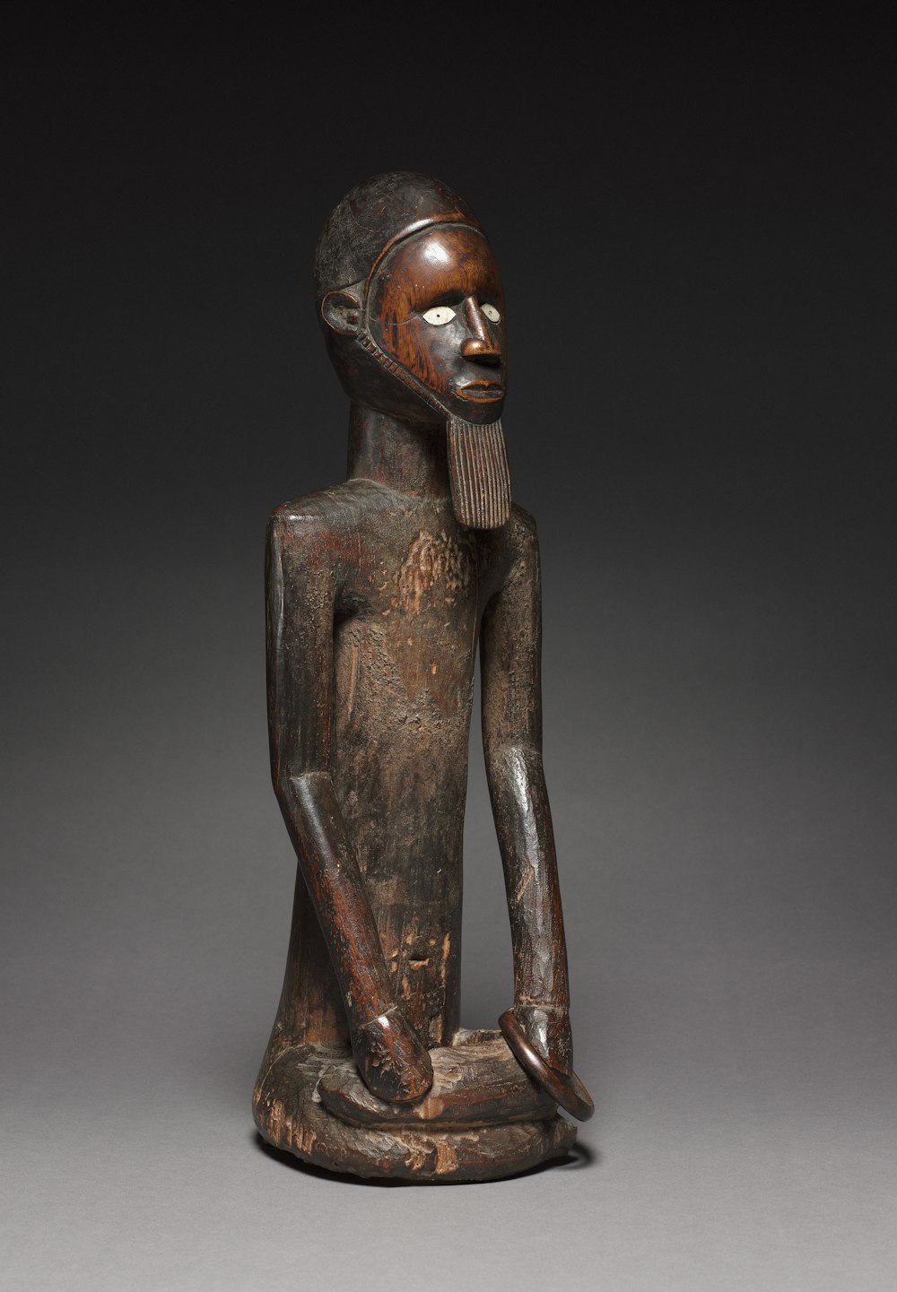 a wooden statue of a seated person