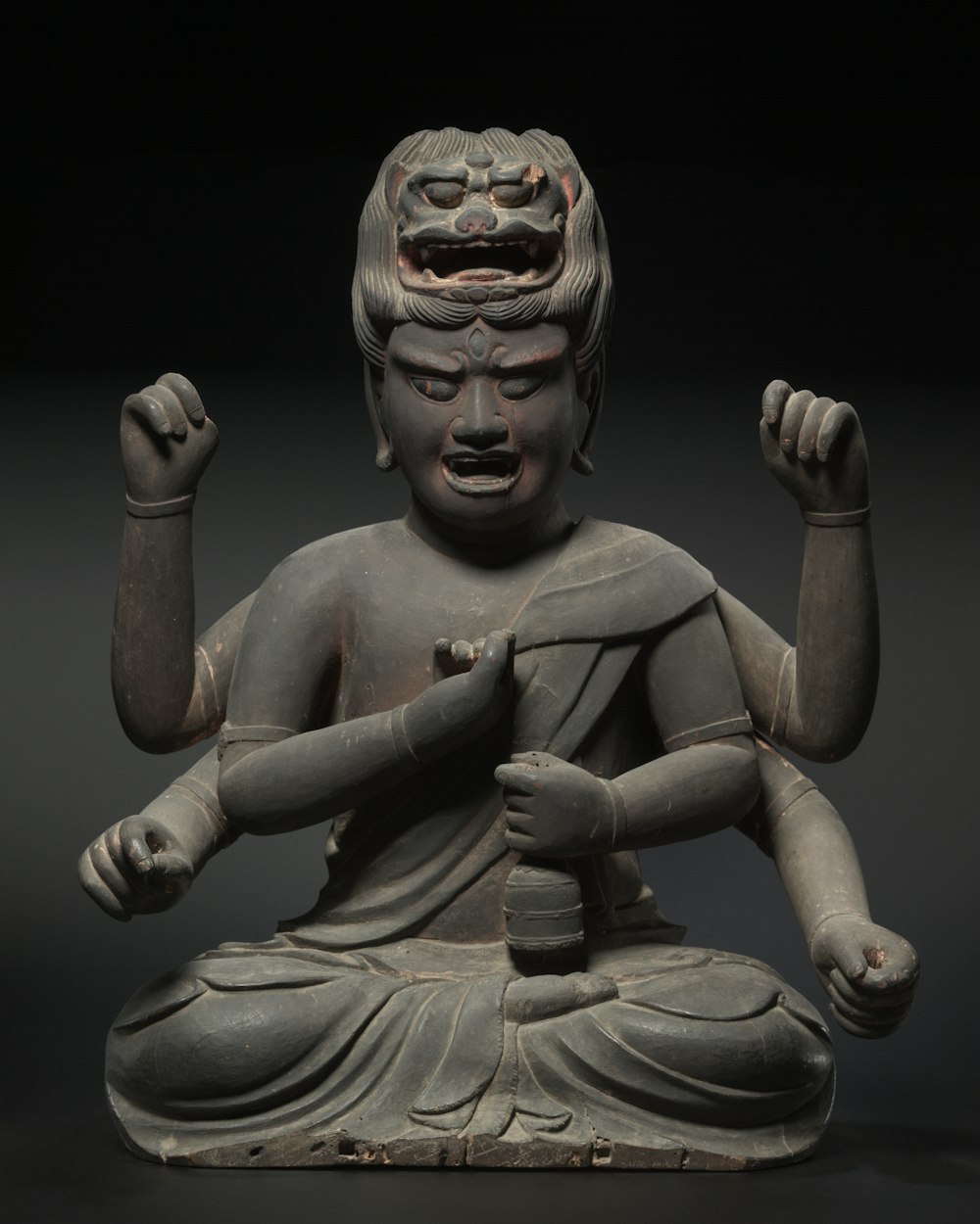 a statue of a seated buddha with his hands in the air