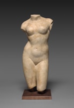 a statue of a woman standing on a wooden base