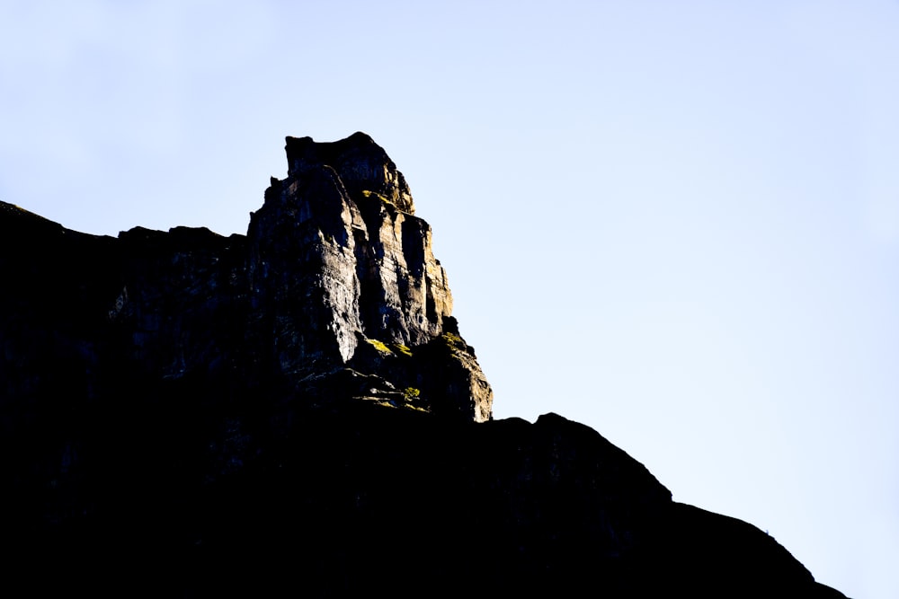 a tall rock formation with a sky background