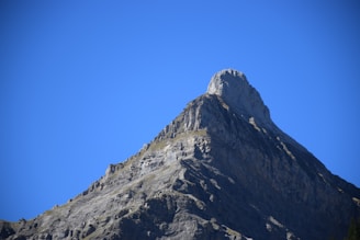 The towering peak of Mount Kilimanjaro against a bright blue sky.