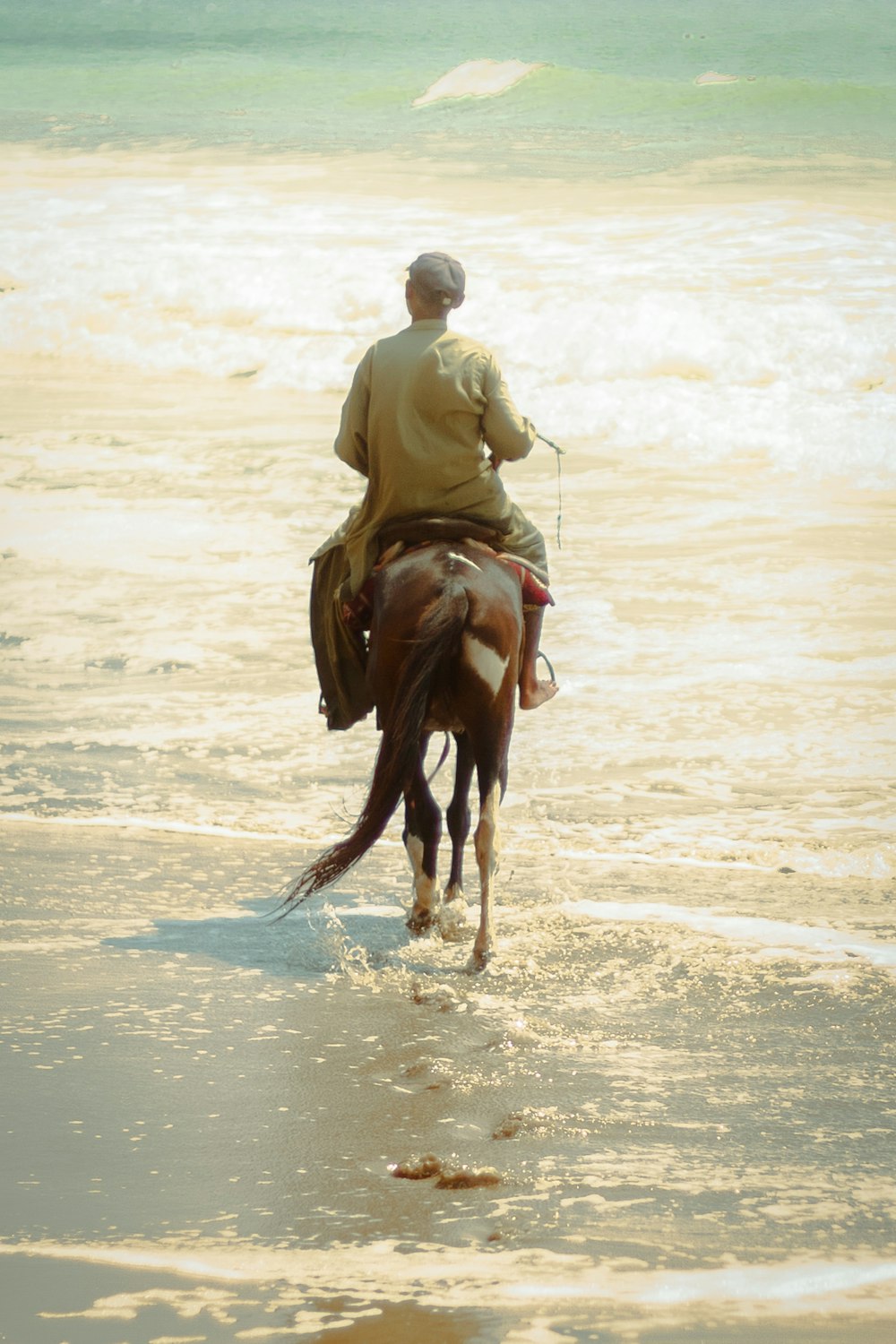 a man riding a horse on the beach