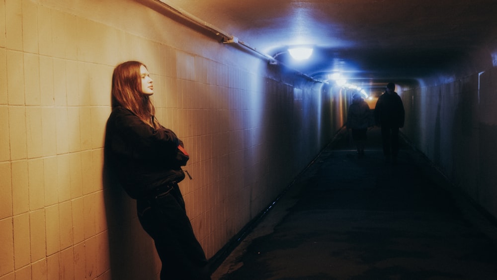 a woman is standing in a long hallway