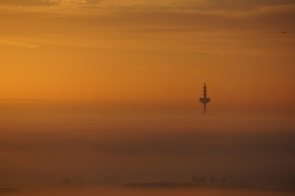 a foggy sky with a tower in the distance