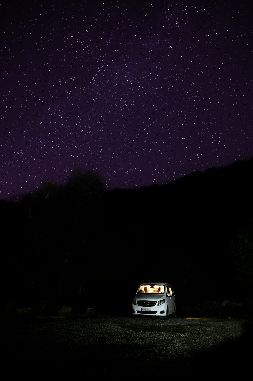 a car parked on a road under a night sky