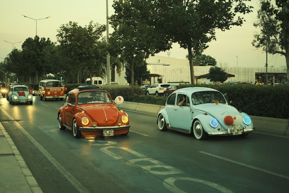 a group of cars driving down a street next to trees