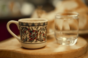 Close-up shot of a colorful ceramic cup with intricate hand-painted designs on a wooden table
