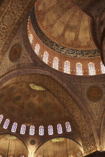 An intricate mosque interior showcasing detailed geometric patterns and warm lighting.