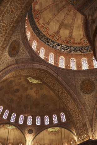 An intricate mosque interior showcasing detailed geometric patterns and warm lighting.