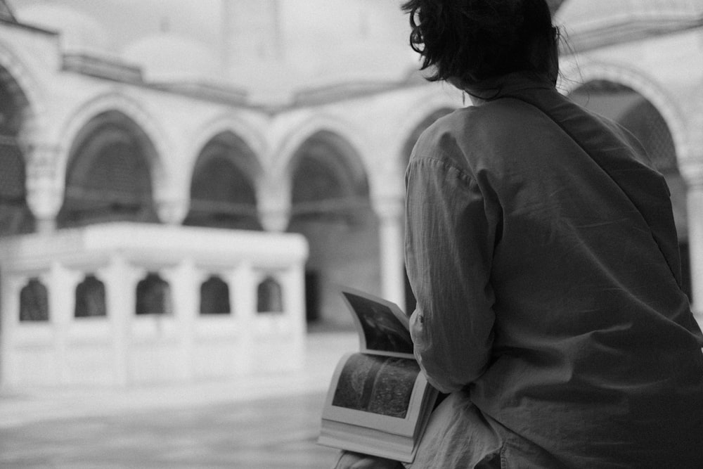 a person sitting on a bench reading a book