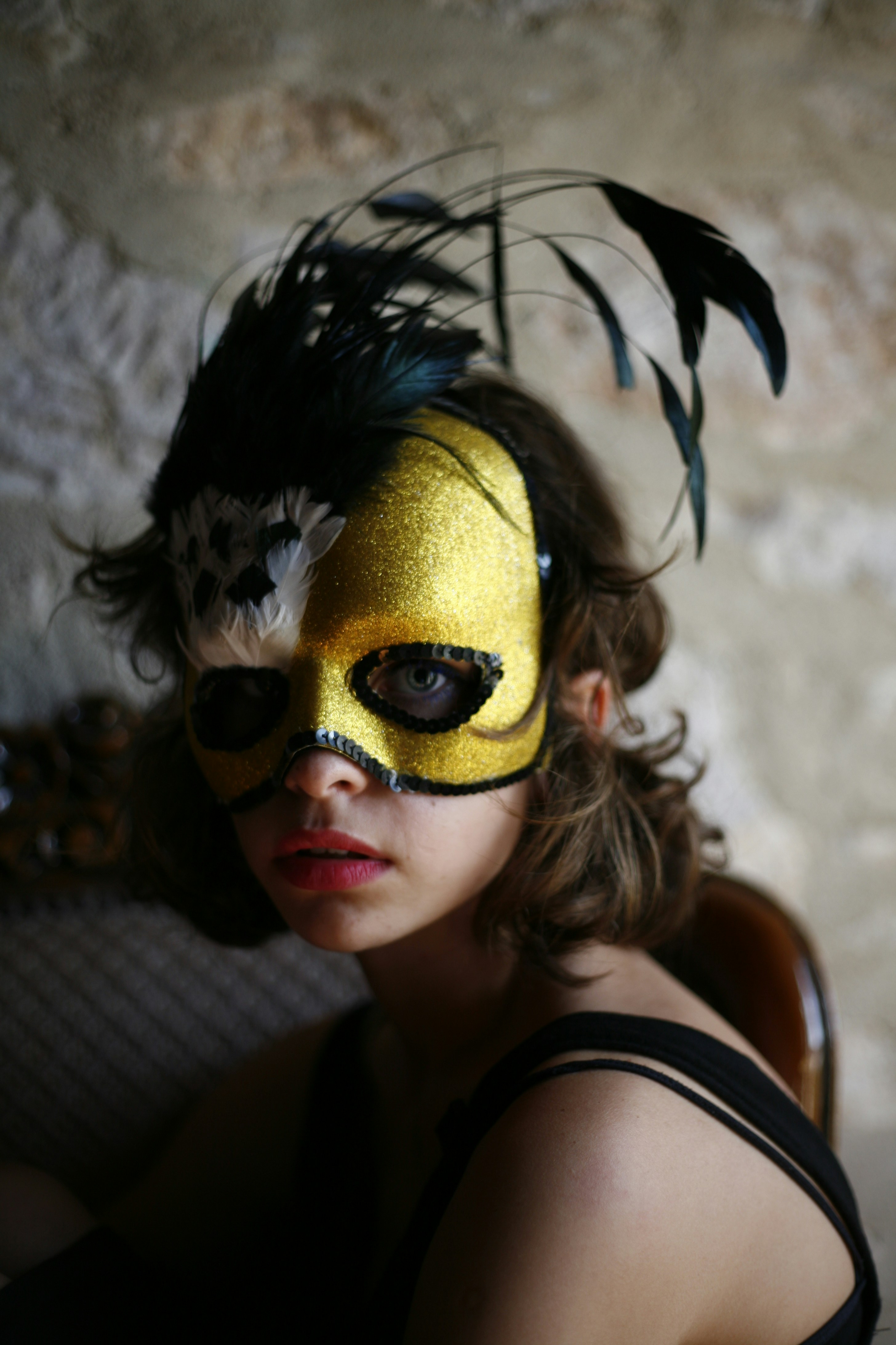 a woman wearing a mask with feathers on it