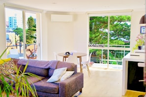 A welcoming living room with a sofa and decorative plants.