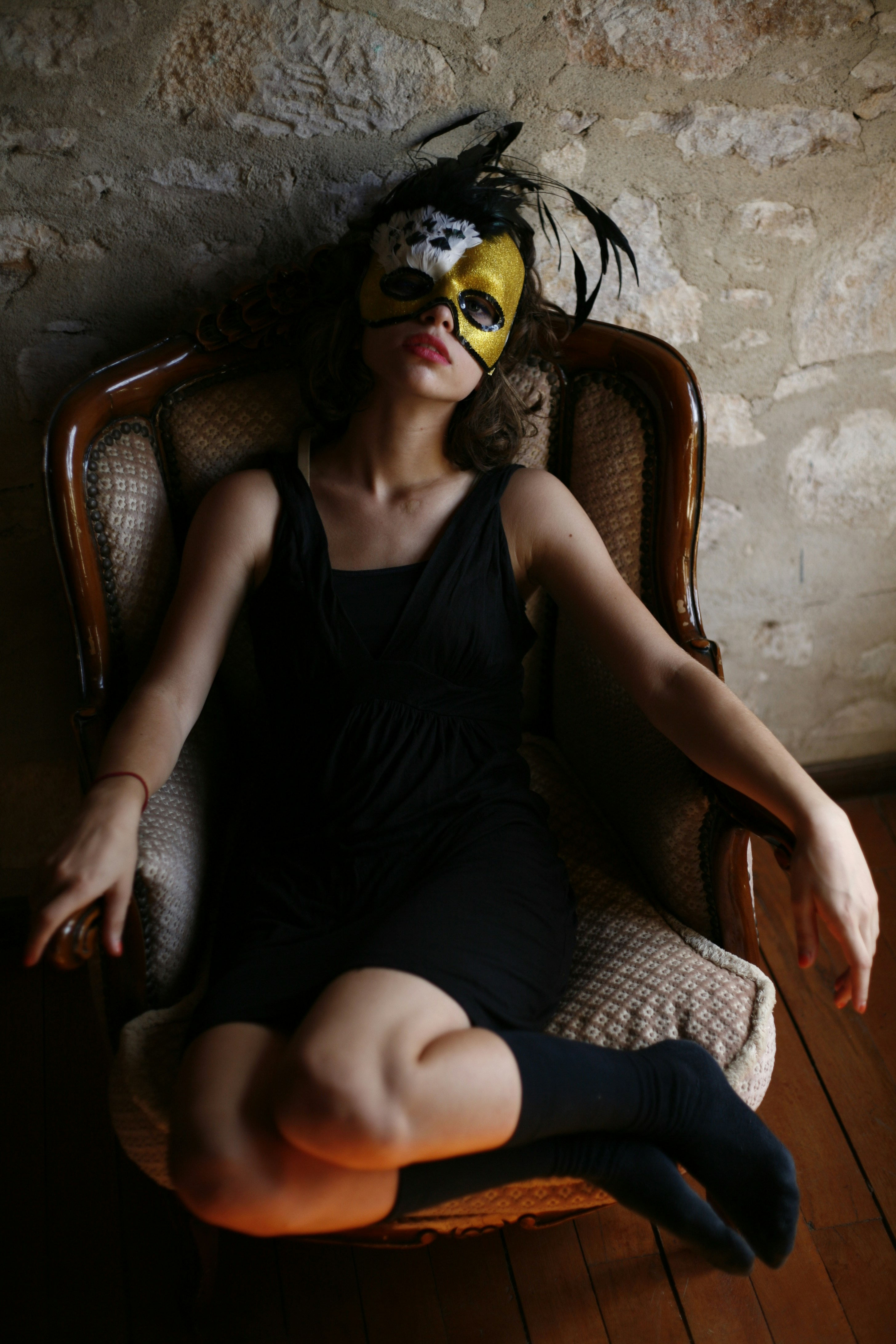 a woman sitting on a chair wearing a mask