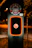 Close-up of a modern DC fast charger glowing with electric blue accents at dusk.