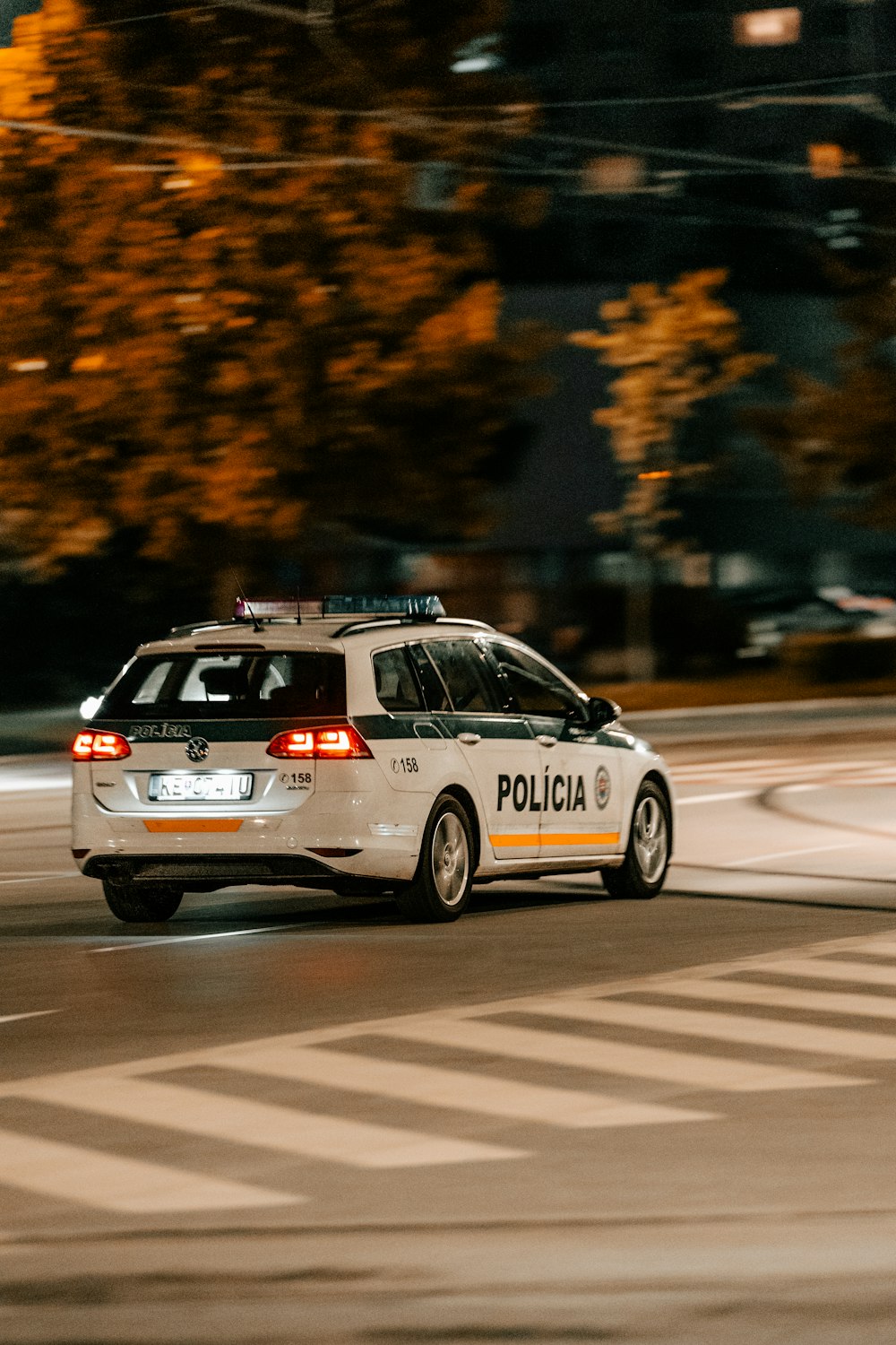 a police car driving down a street at night