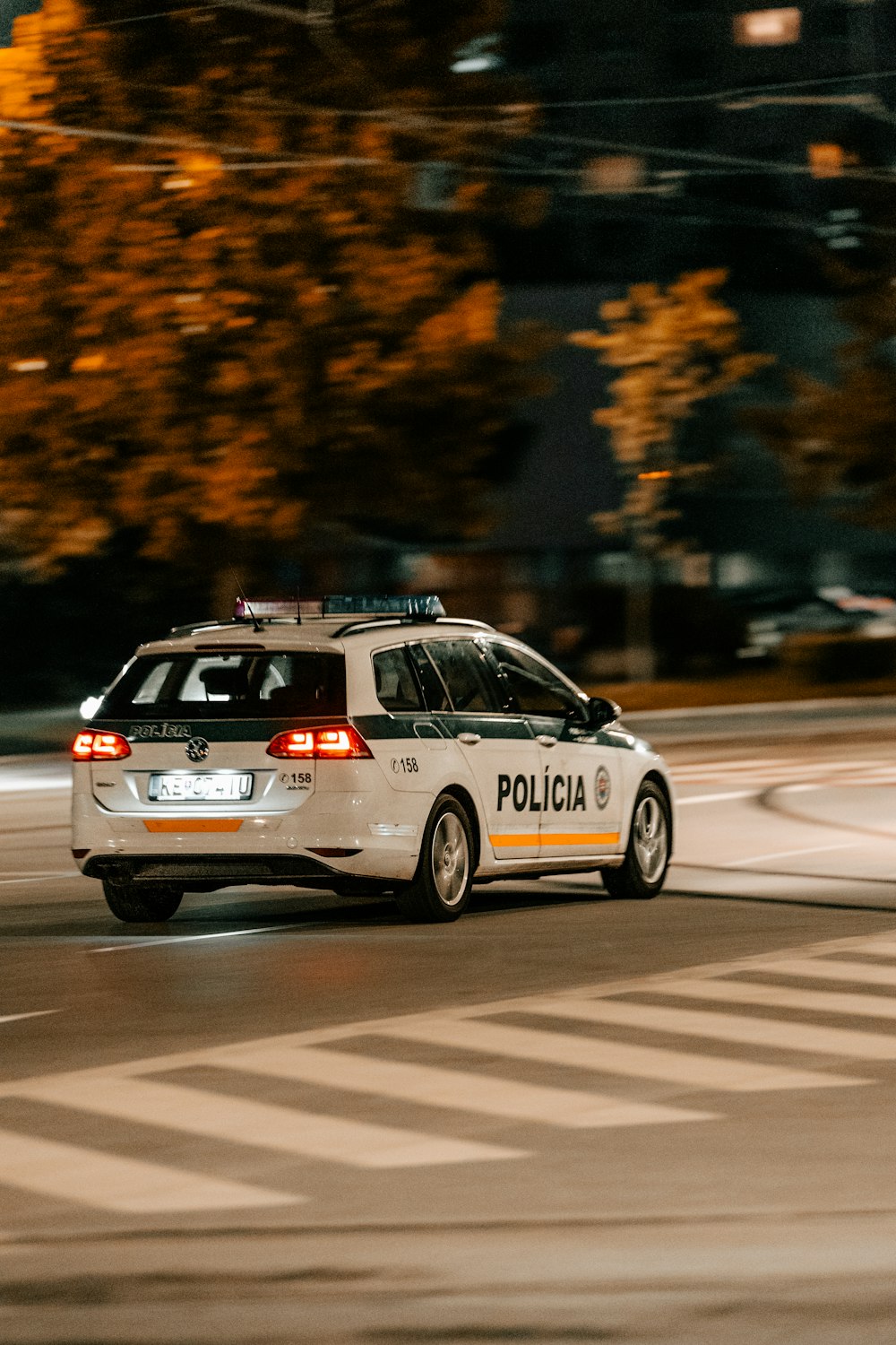 Un coche de policía conduciendo por una calle de noche