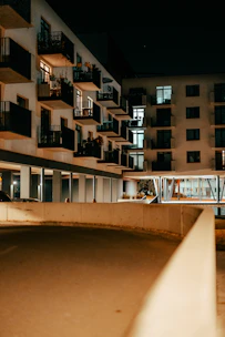 Night view of a luxury redevelopment project with illuminated balconies and landscaped surroundings.