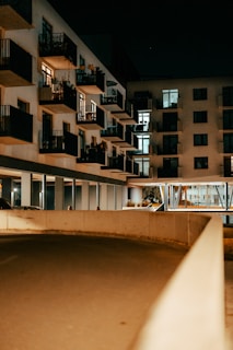 Evening view of the property with warm lights glowing from balconies.