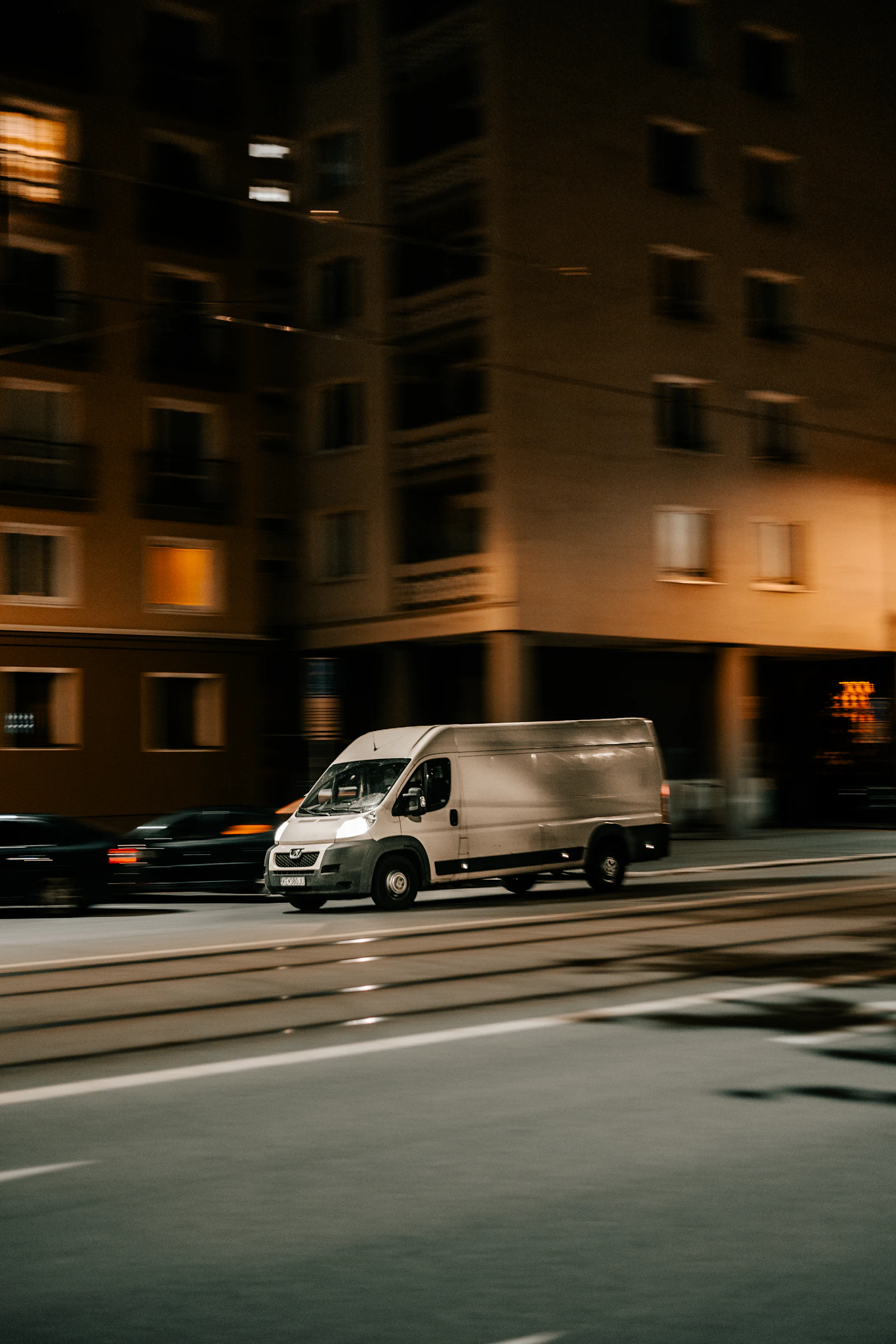A delivery van moving through city streets at night, the last mile a cannabis dispatch system has to account for
