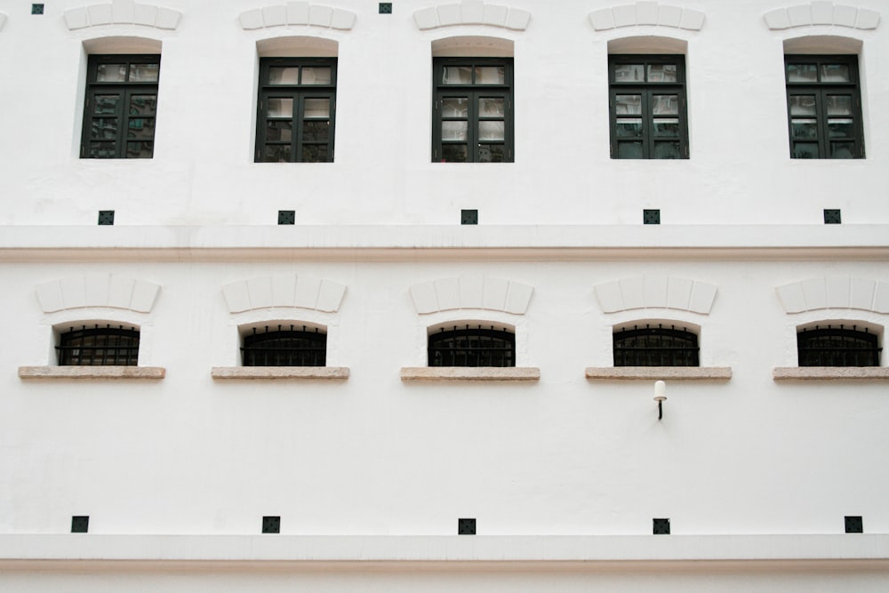 a white building with several windows and a clock