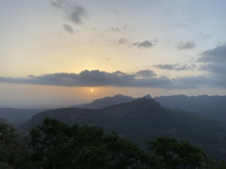 A serene landscape showcasing a tranquil sunset over a mountain range.