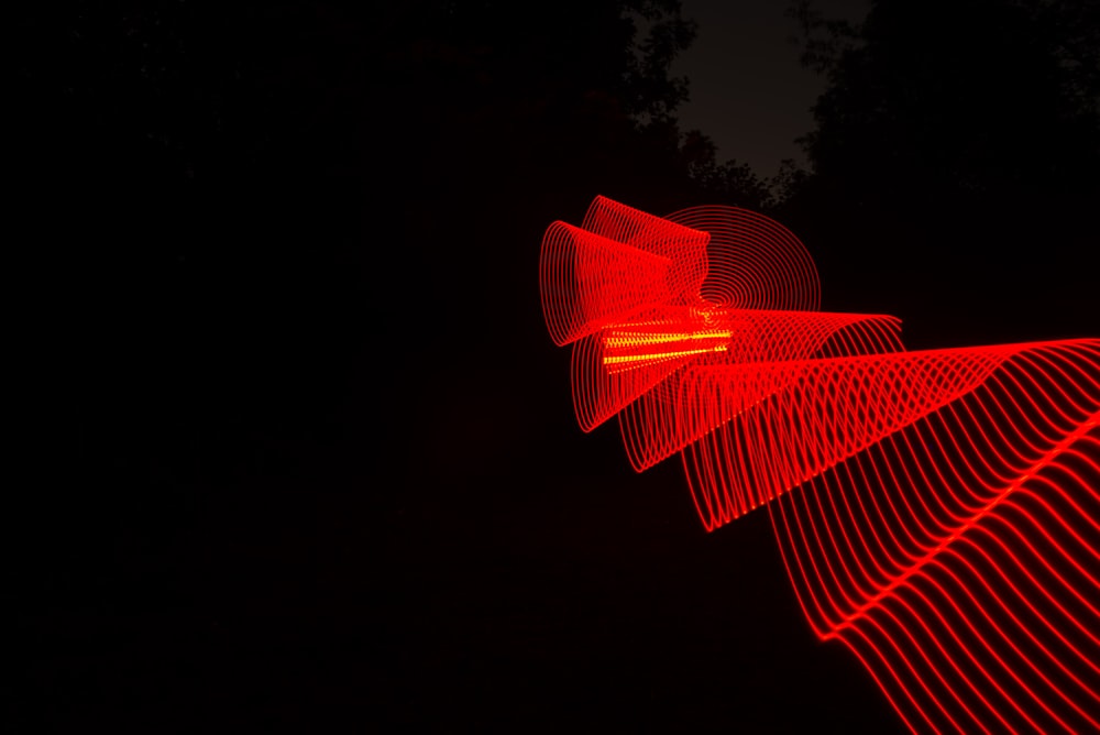 a long exposure photo of a red light in the dark