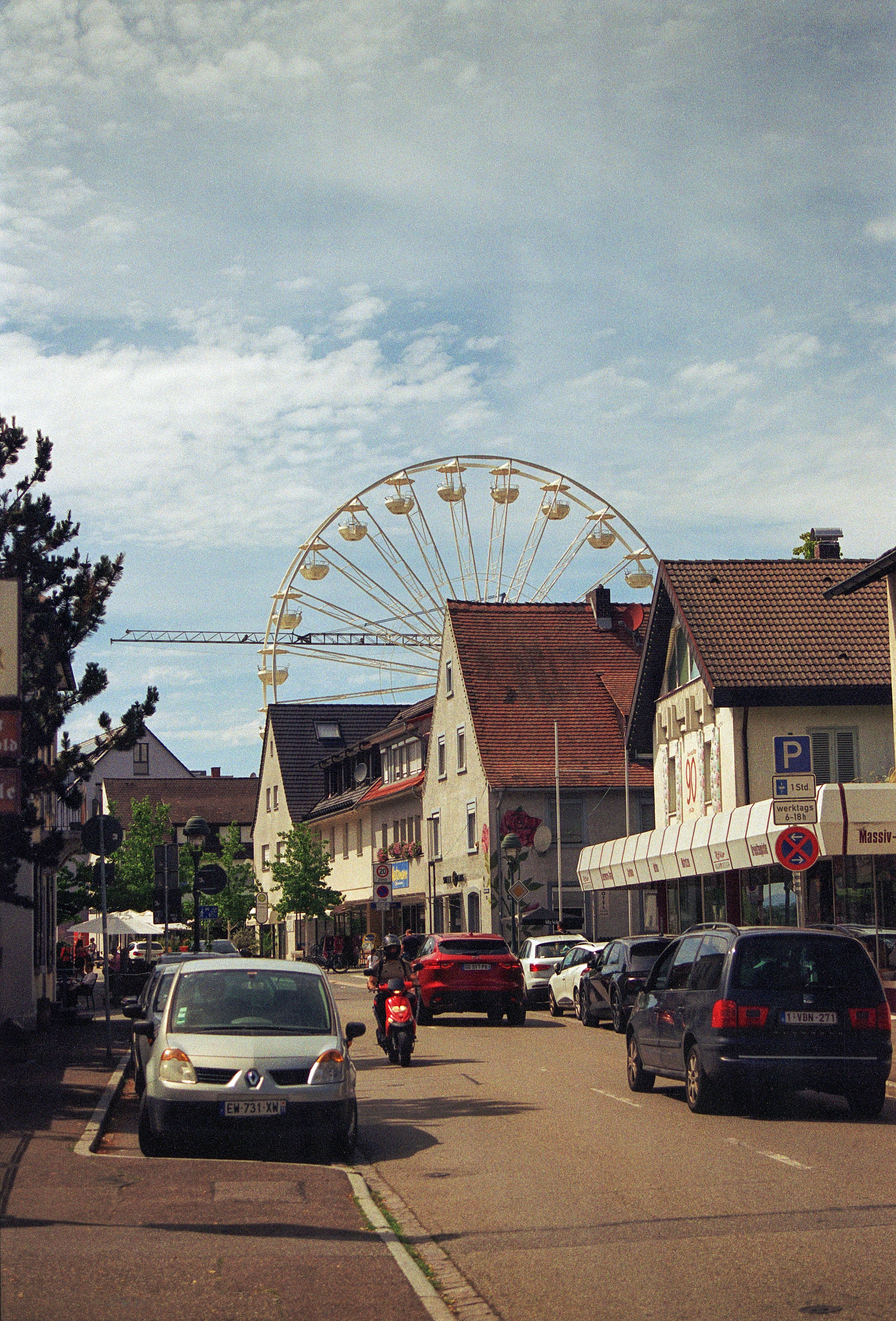 Eine Stadtstraße mit einem Riesenrad im Hintergrund
