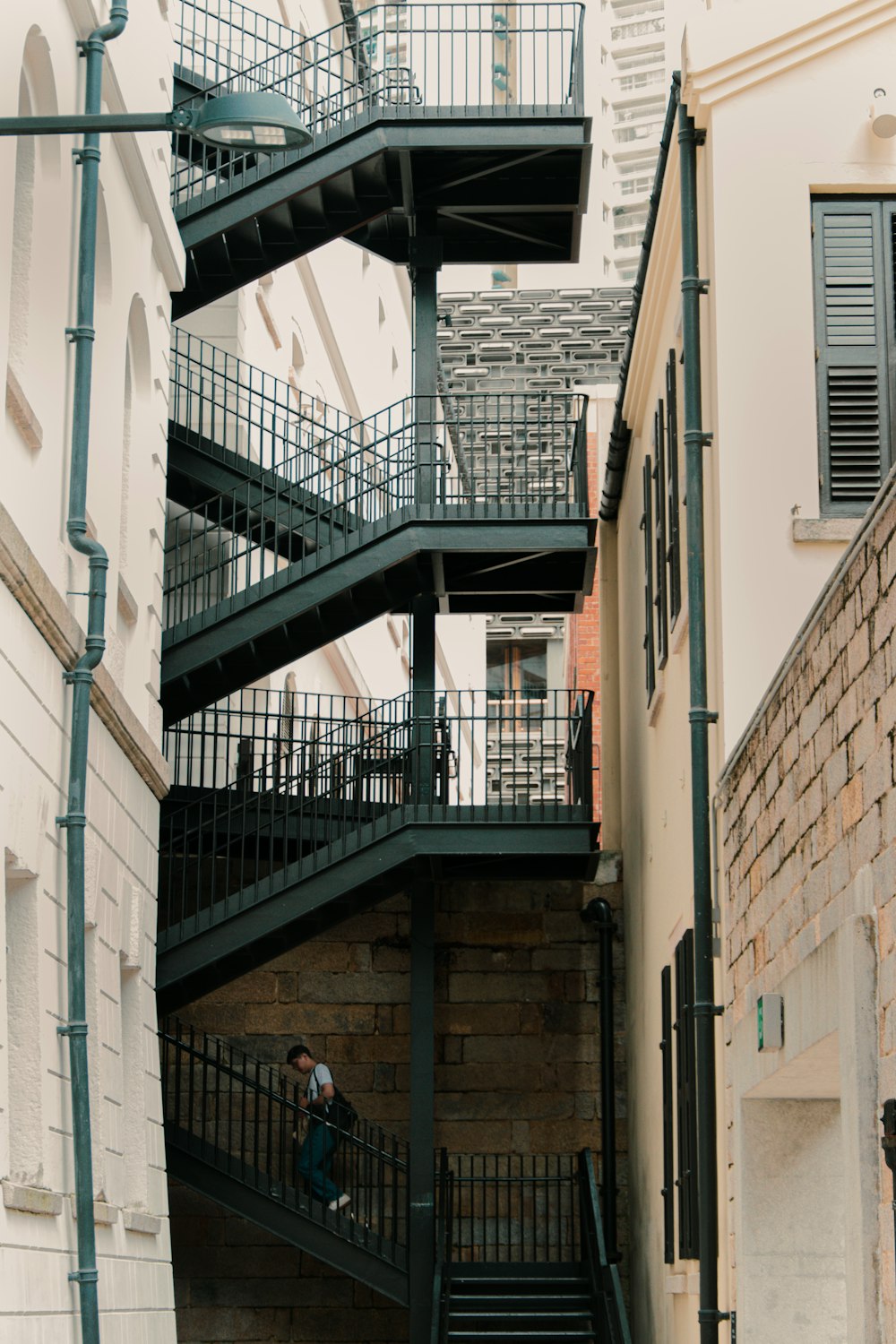 a man walking down a set of stairs next to a building