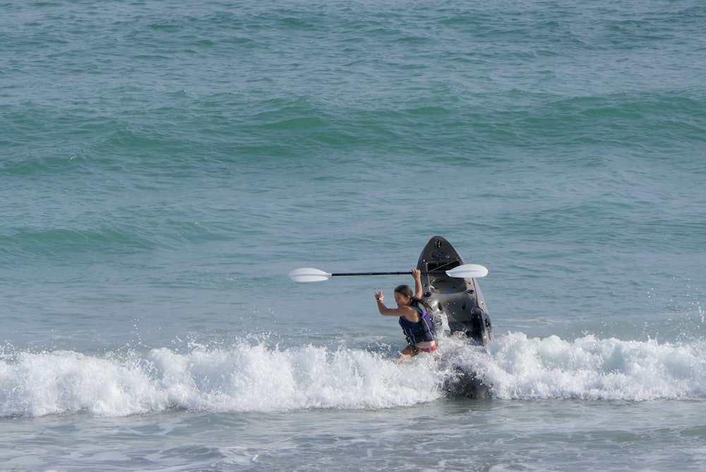 a man and a woman are in the water with a boat