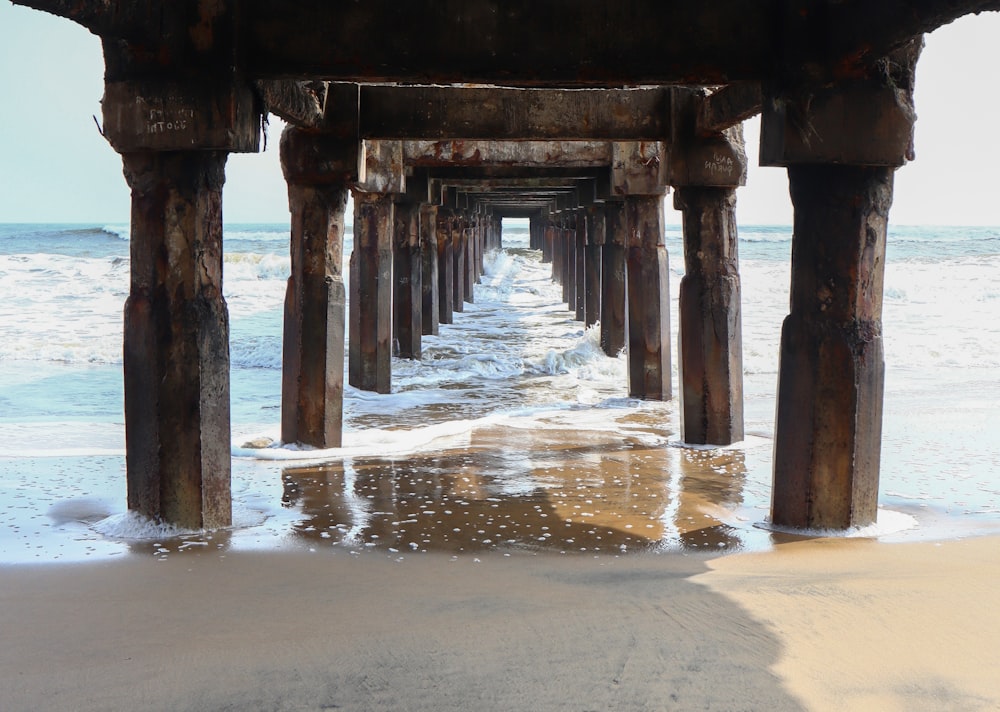 a view of the ocean from underneath a pier