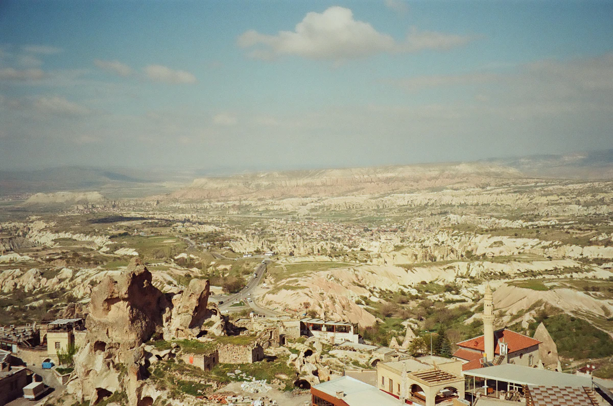 Eroded valleys and pinnacles stretching away from Uçhisar, with rooftops in the foreground