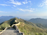 A panoramic view of the Great Wall winding over rugged mountains under a clear blue sky.