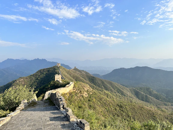 A panoramic view of the Great Wall winding over rugged mountains under a clear blue sky.