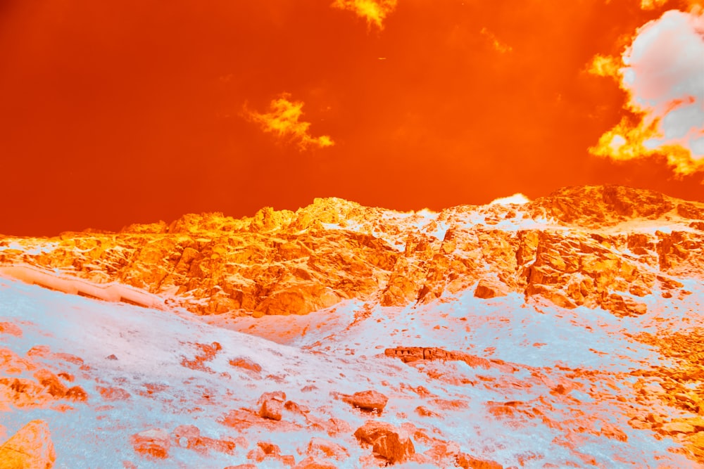 a mountain covered in snow under a cloudy sky