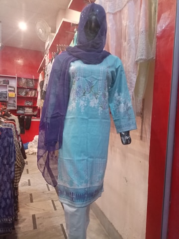 A vibrant display of colorful sarees and kurtis arranged on mannequins in a bright boutique.