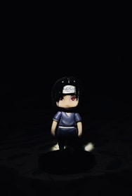 A close-up of a dark chibi-style 3D printed figurine with glowing eyes.