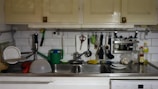 A kitchen countertop covered in dishes and groceries before a thorough cleaning and organizing session.