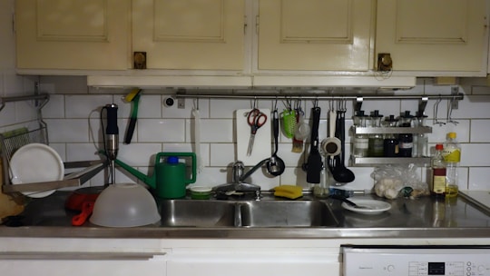 A bright kitchen countertop with dishcloths drying beside a clean sink.