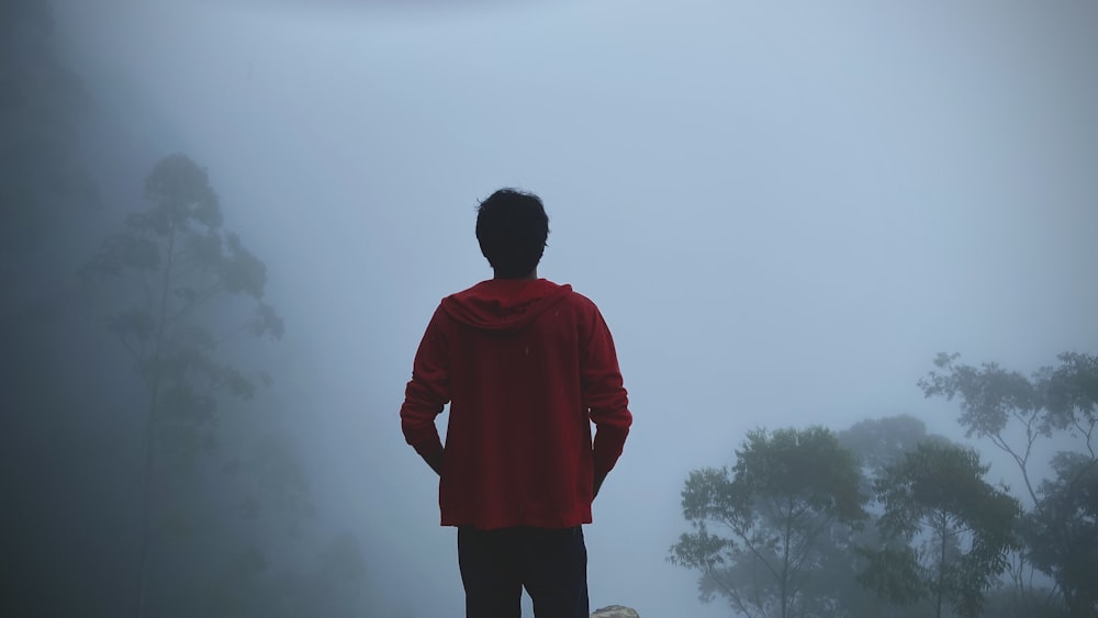 a man standing in the fog with his back to the camera