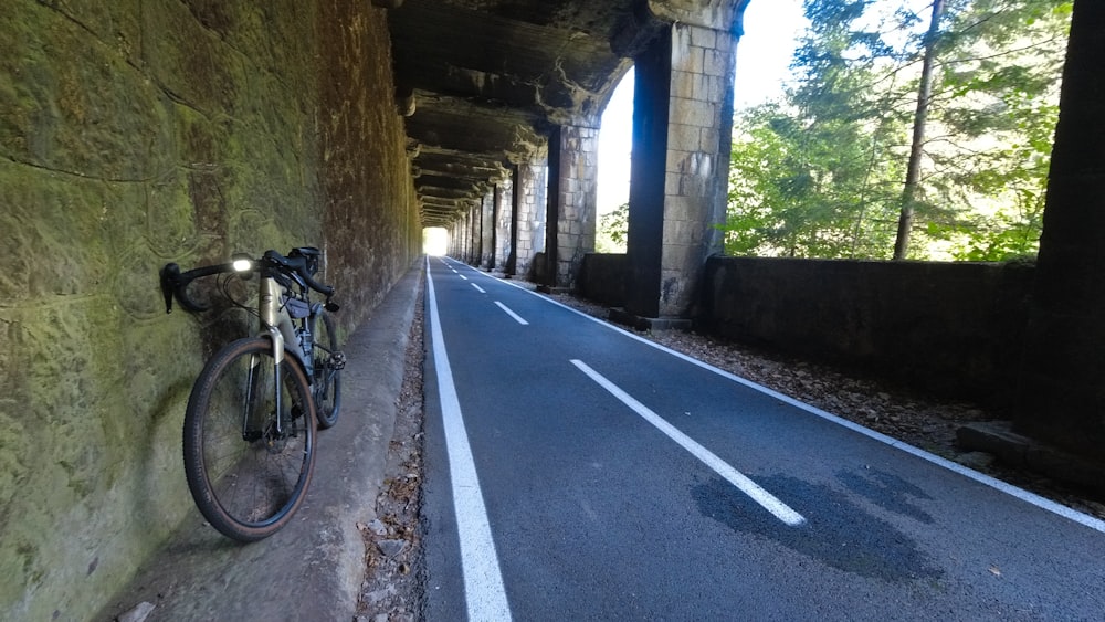 a bike leaning against a wall on the side of a road