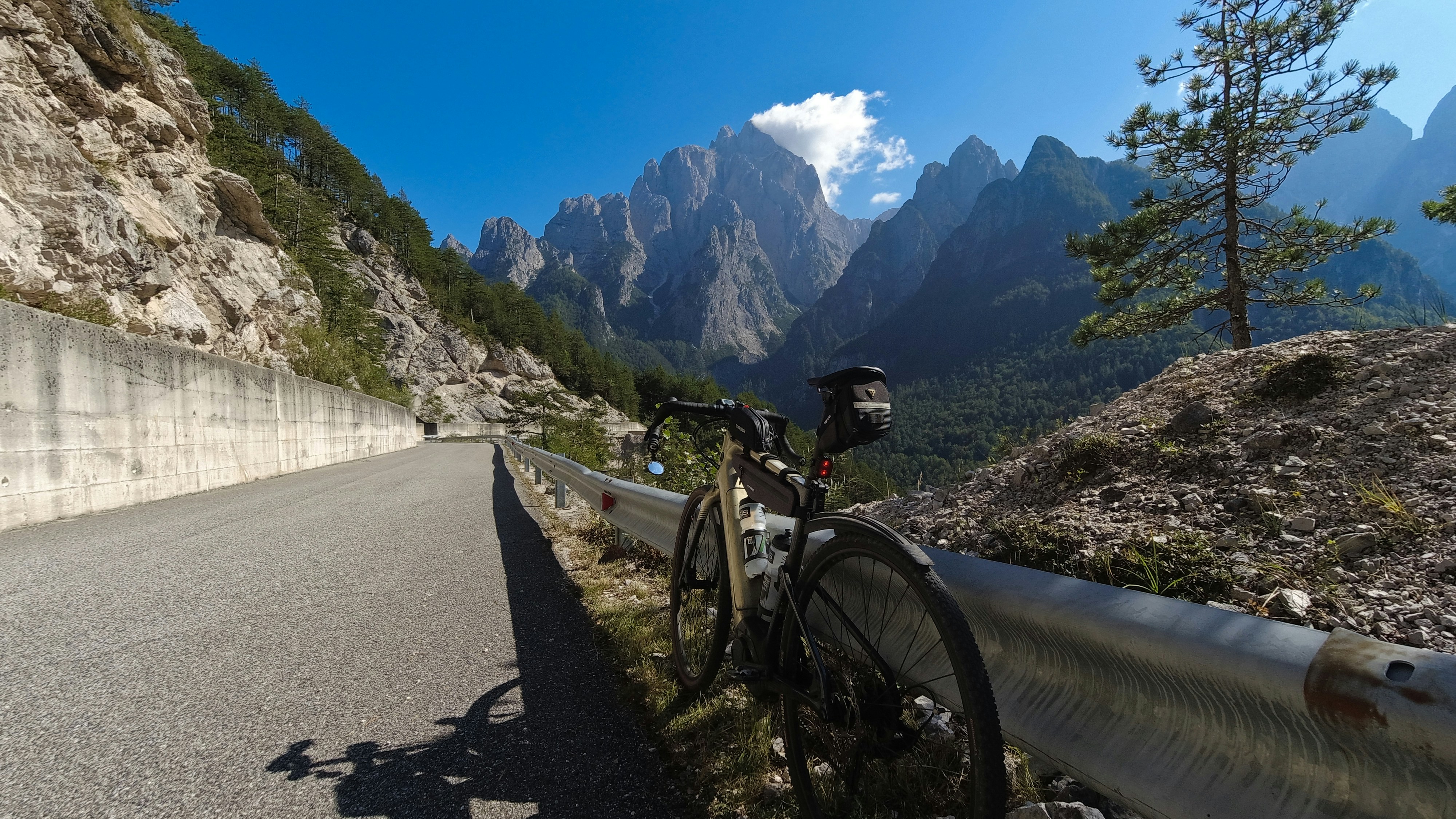 a bicycle parked on the side of a mountain road