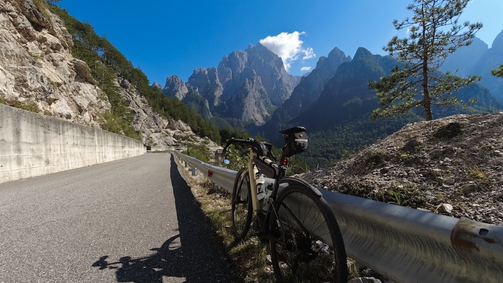 a bicycle parked on the side of a mountain road