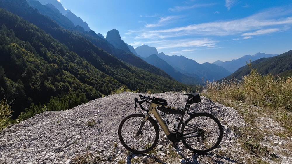 a bicycle is parked on a rocky hill