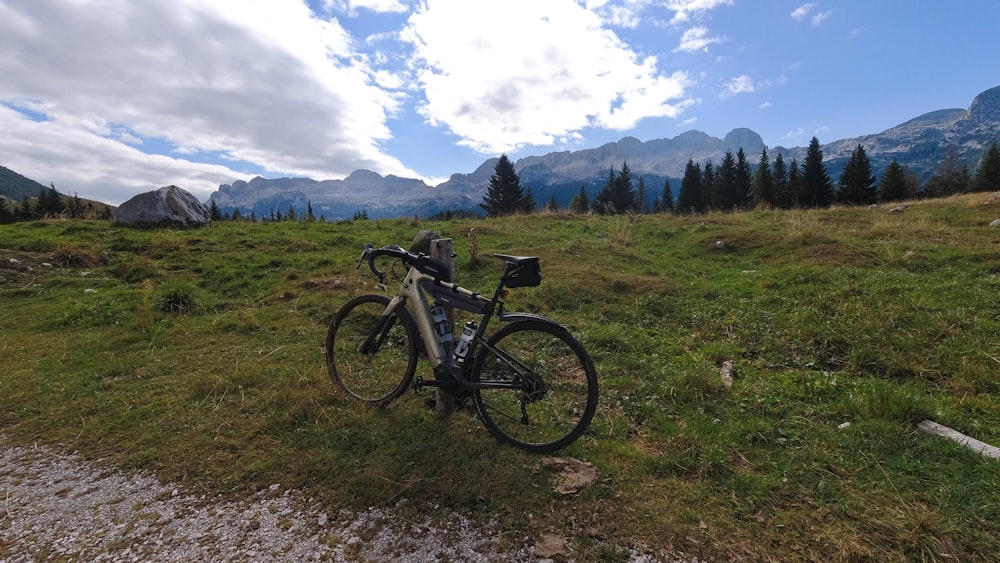 a bicycle parked on the side of a dirt road