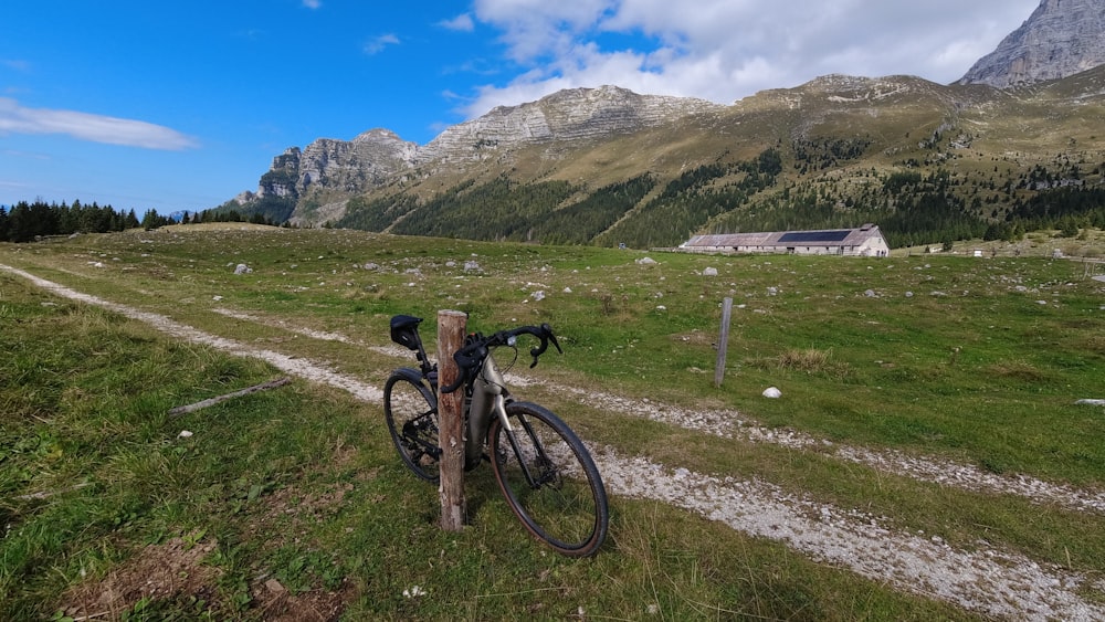 a bike leaning against a post in a field