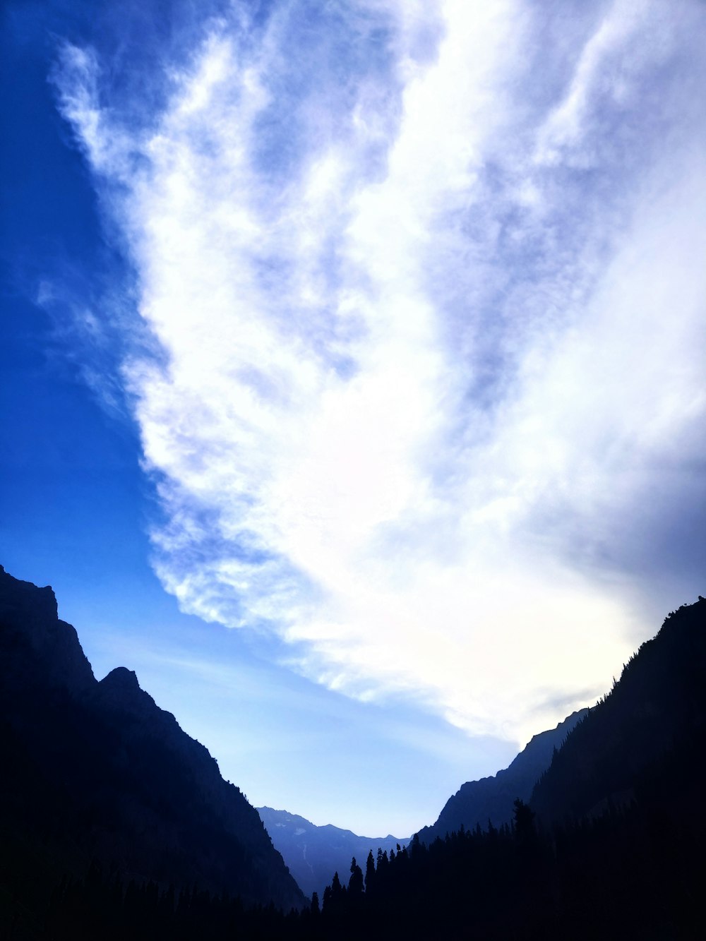 a view of a mountain range with clouds in the sky