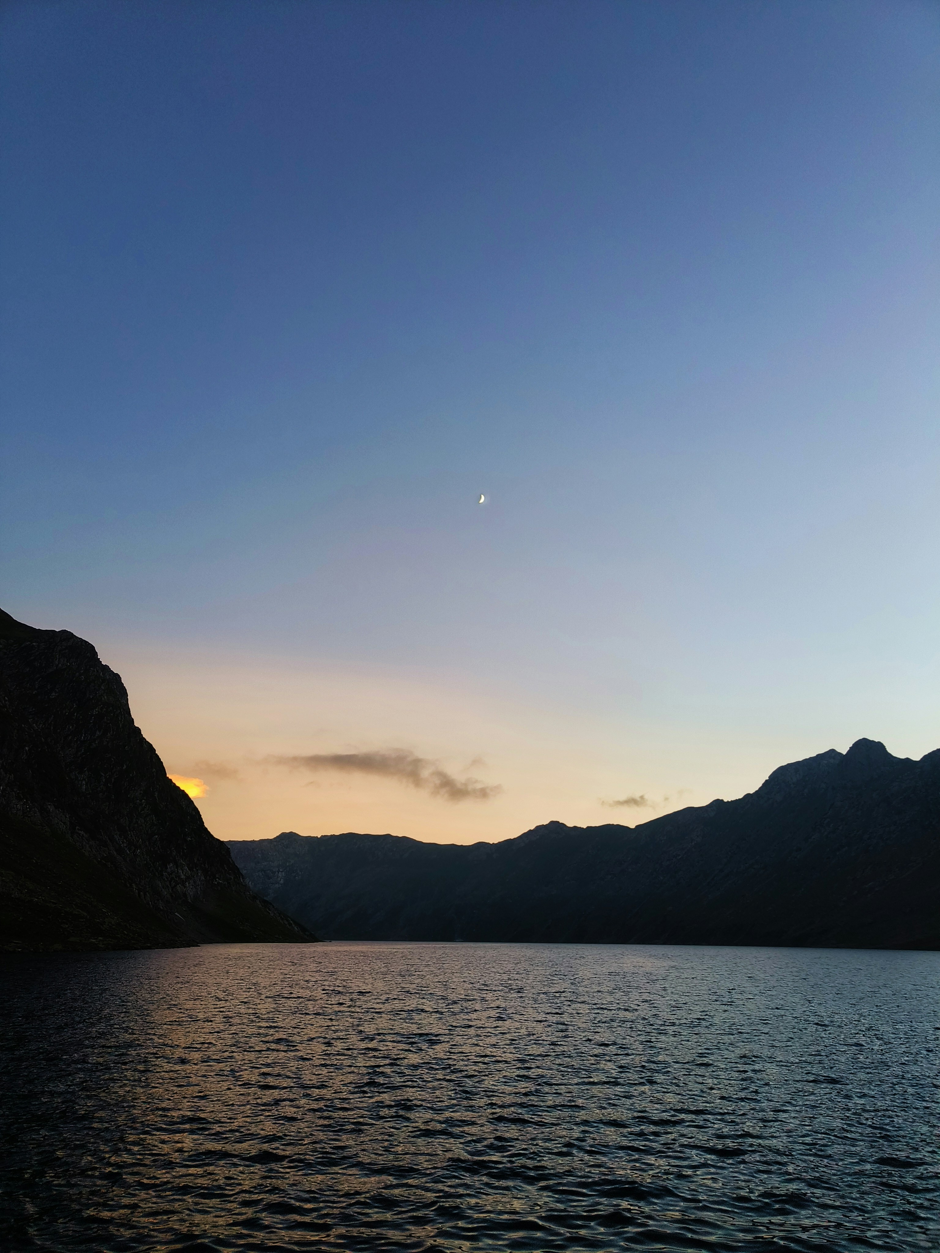 a body of water with mountains in the background